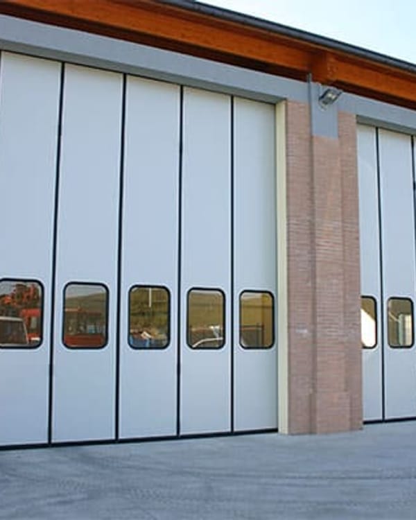 Portone a libro su un capannone industriale con ante ripiegate lateralmente