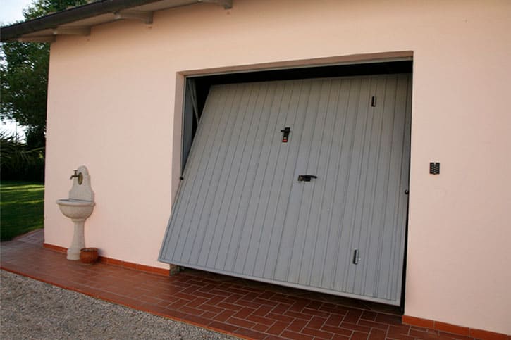 Porta basculante in acciaio aperta su un garage residenziale