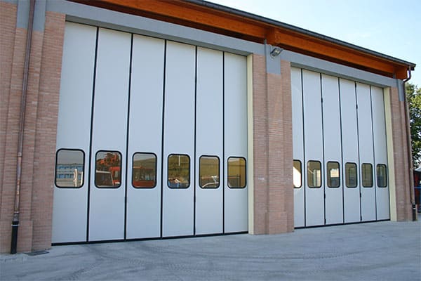 Portone a libro su un capannone industriale con ante ripiegate lateralmente