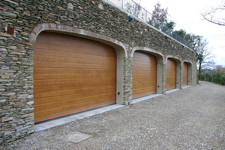 Portone sezionale con pannelli effetto legno su una villa residenziale