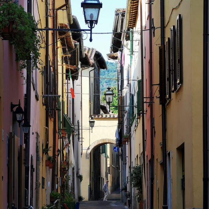 Vicolo caratteristico del centro storico di Sansepolcro tra facciate colorate e un antico lampione