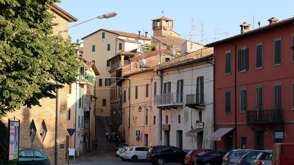 Via del centro storico di Umbertide con le facciate colorate e la torre sullo sfondo